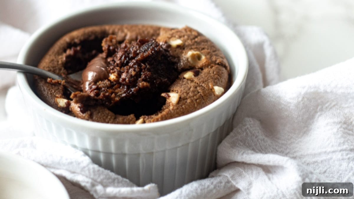 bowl of nutella baked oats with hazelnuts on top