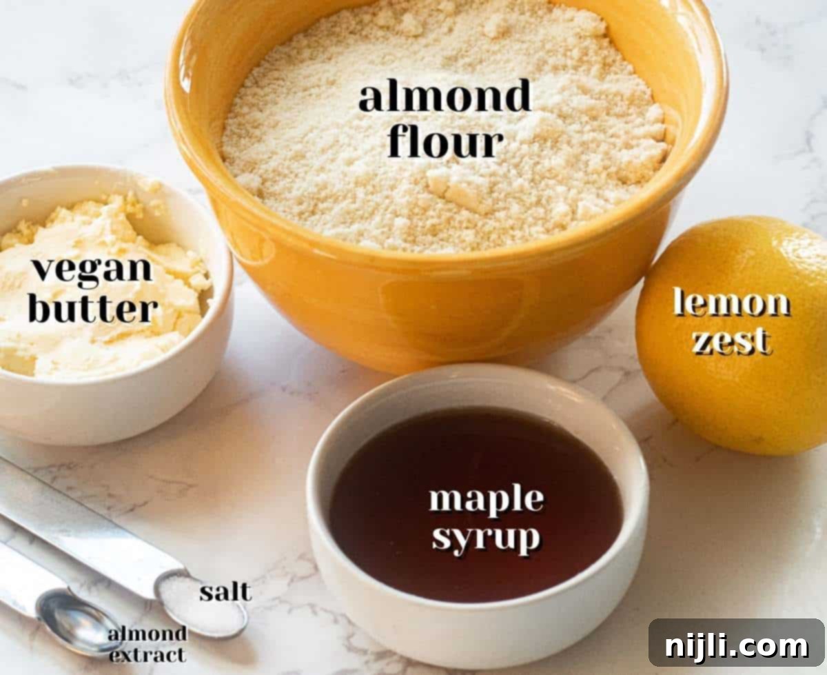 Nutty Lemon Bliss Cookies 3 Ingredients laid out for vegan almond flour lemon cookies, including flour, butter, syrup, and lemons.