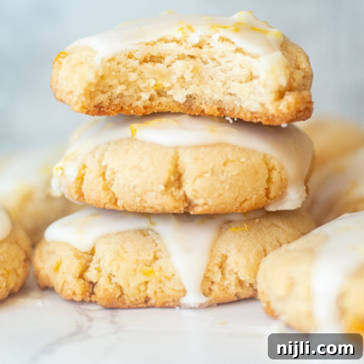 Nutty Lemon Bliss Cookies 4 Close-up of a soft almond flour lemon cookie with a bite taken out, showing the tender crumb and delicate glaze.