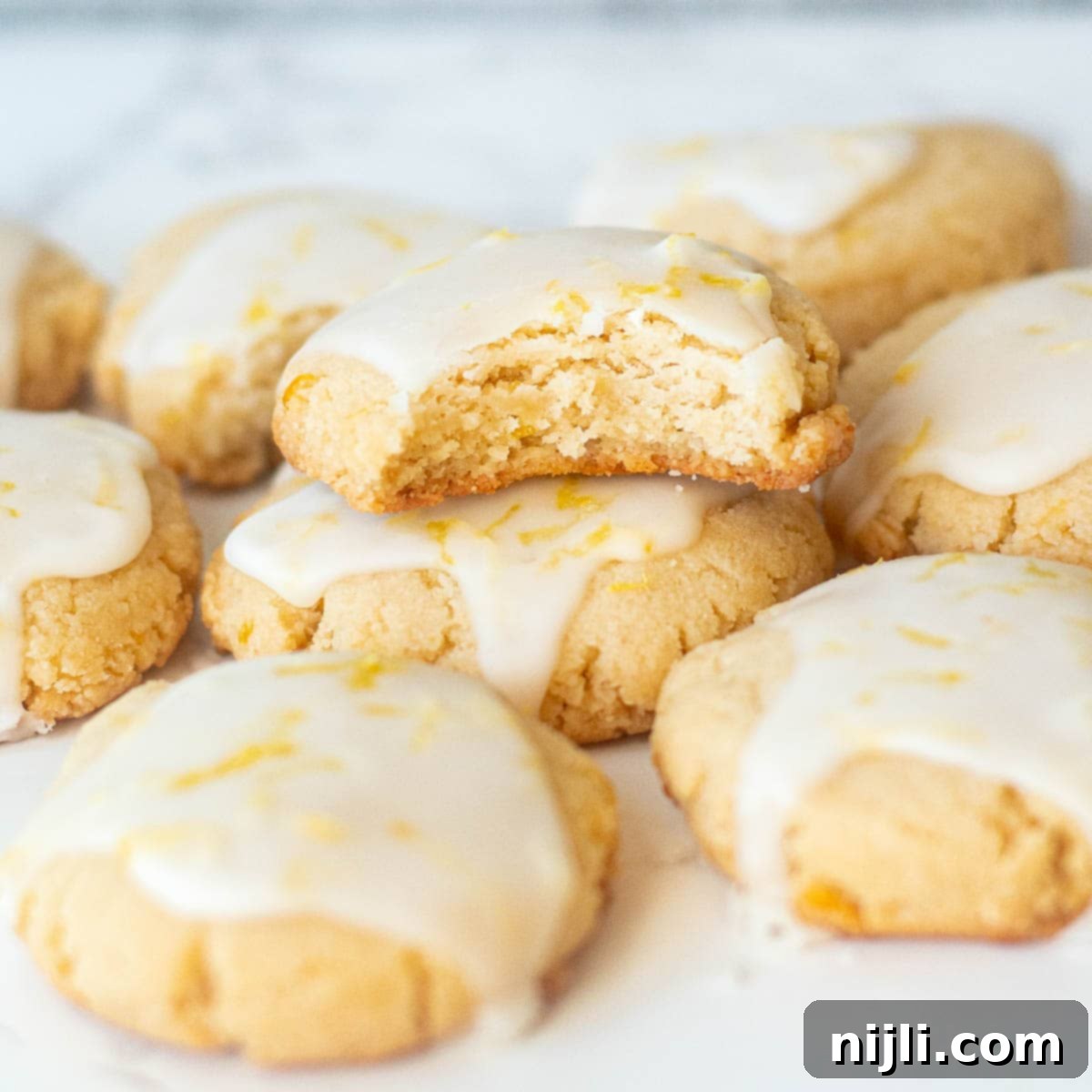 Nutty Lemon Bliss Cookies 8 Stacked almond lemon cookies on a plate, featuring their perfect shape and inviting glaze.
