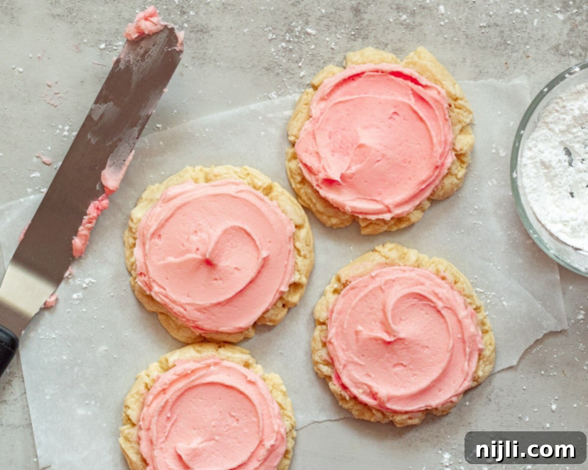 Copycat Crumbl Sugar Cookies 7 chilled sugar cookies on a tray with a spatula nearby