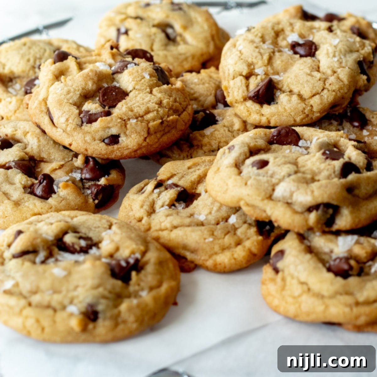 Vegan Chocolate Chip Cookies 2 Delicious dairy free chocolate chip cookies sprinkled with flaky sea salt on a baking tray, ready to be enjoyed