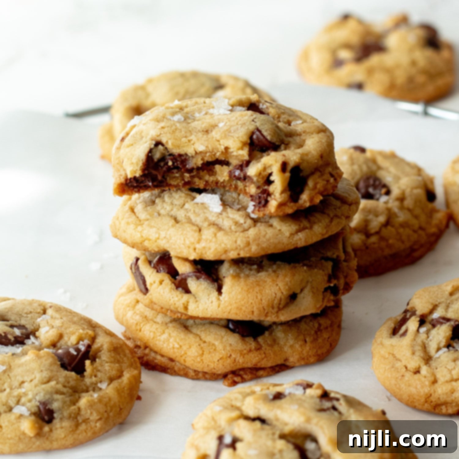 A stack of dairy free chocolate cookies with a bite taken out, revealing melted chocolate inside