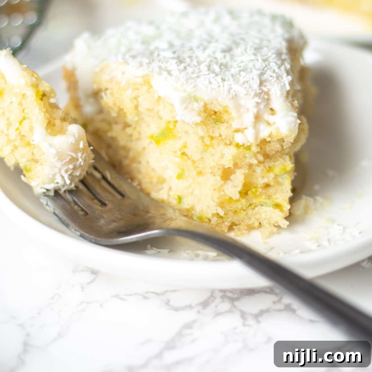 Tropical Vegan Coconut Delight 10 vegan coconut cake with a bite cut out