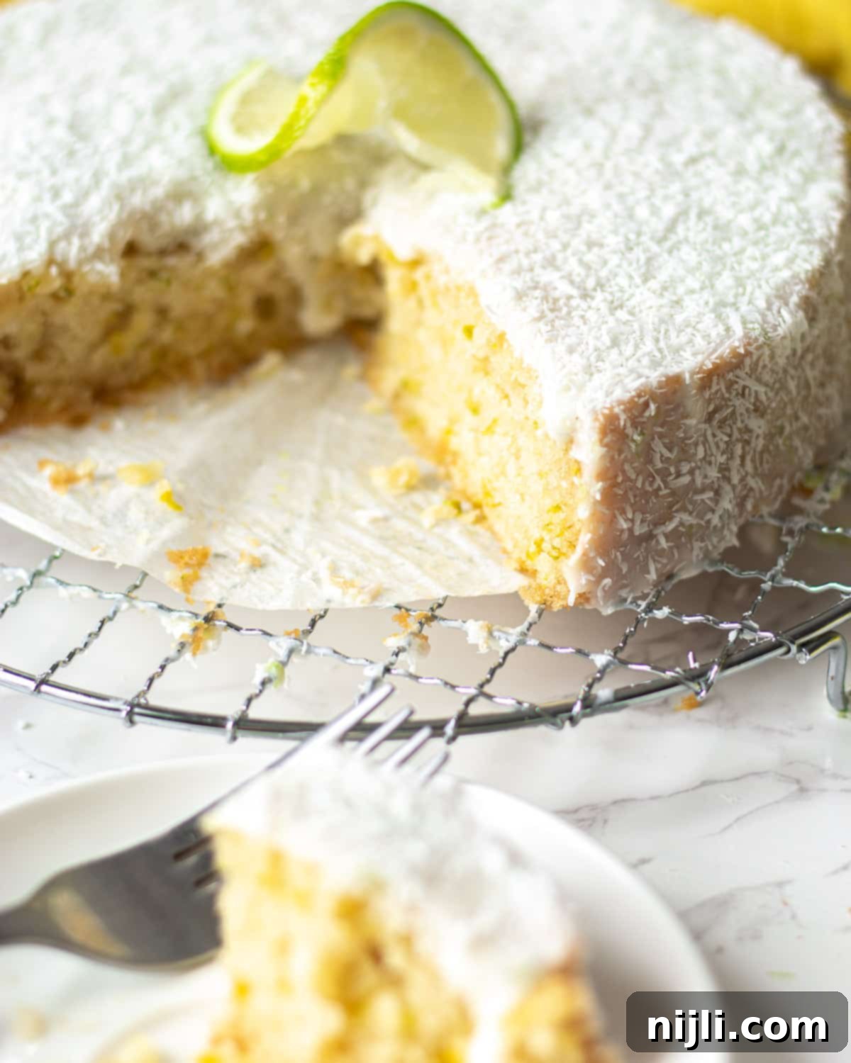 Tropical Vegan Coconut Delight 6 vegan coconut and lime cake with a piece cut out