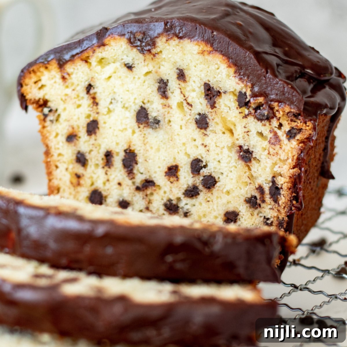 Decadent Chocolate Chip Loaf 3 Delicious slices of chocolate chip pound cake loaf arranged on a tray, highlighting its moist texture and abundance of chocolate chips.