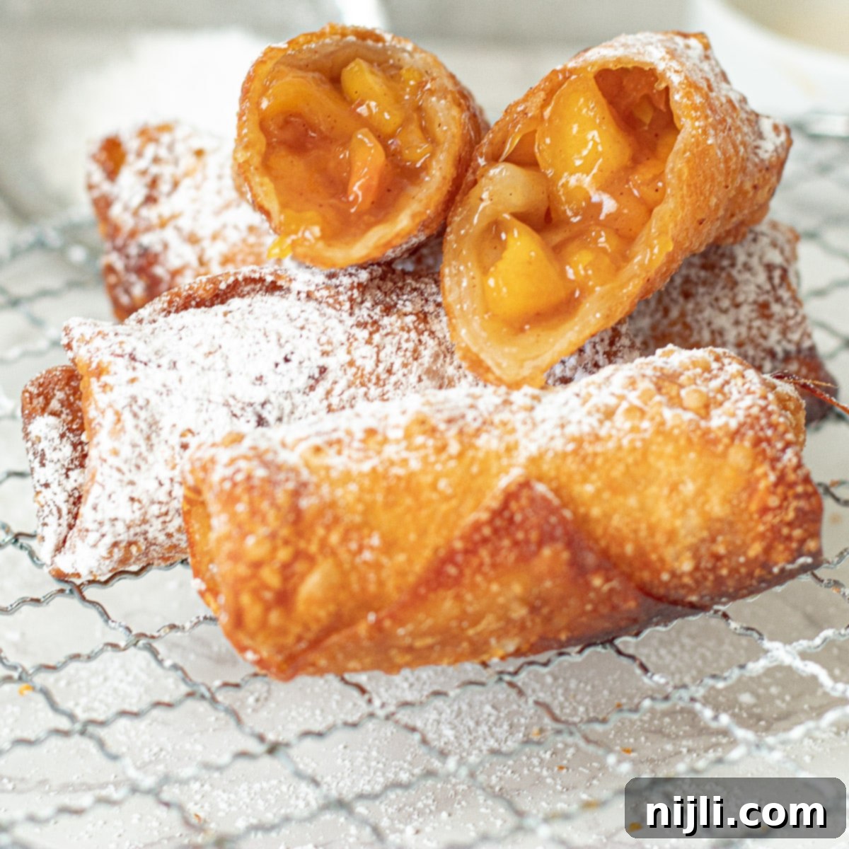 Peach Cobbler Egg Rolls 2 peach cobbler egg rolls on a tray