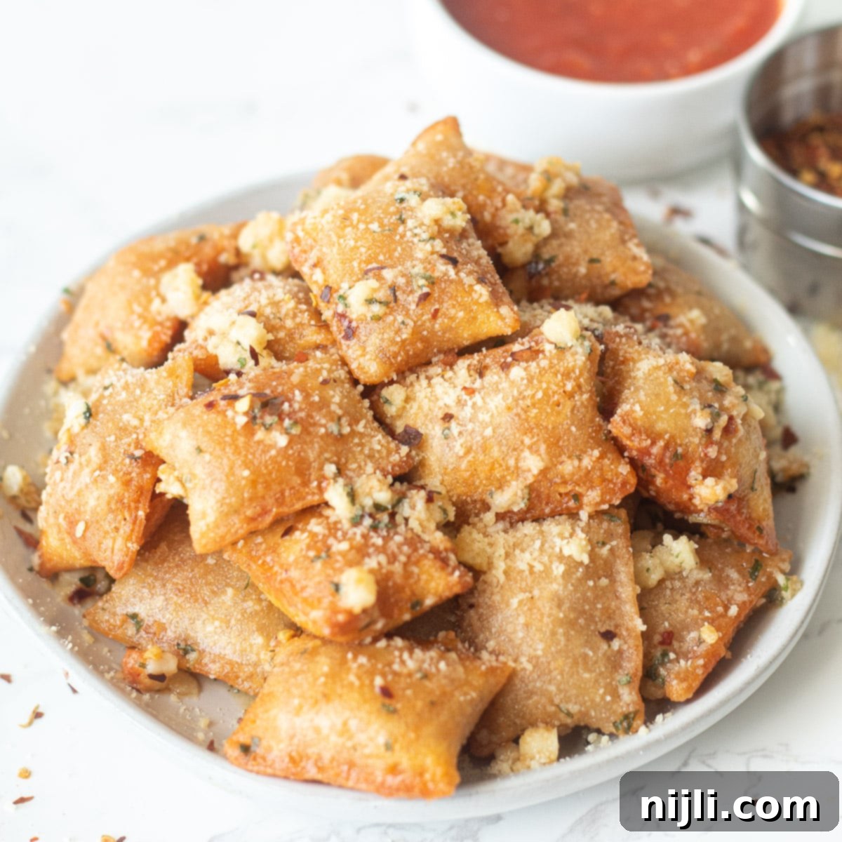 Air Fried Pizza Perfection 2 air fryer pizza rolls in garlic parmesan butter on a plate