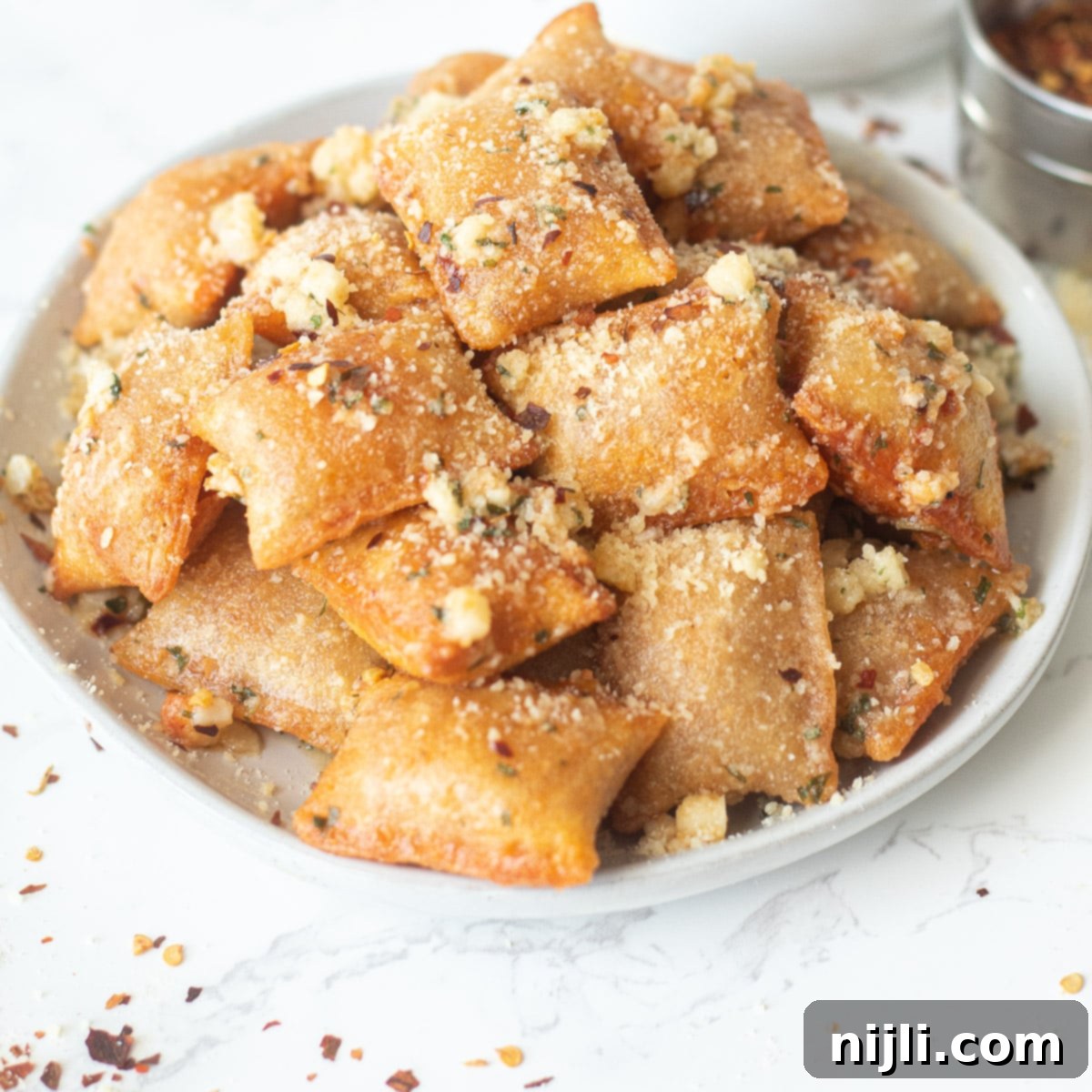Air Fried Pizza Perfection 6 air fryer pizza rolls in garlic parmesan butter on a plate