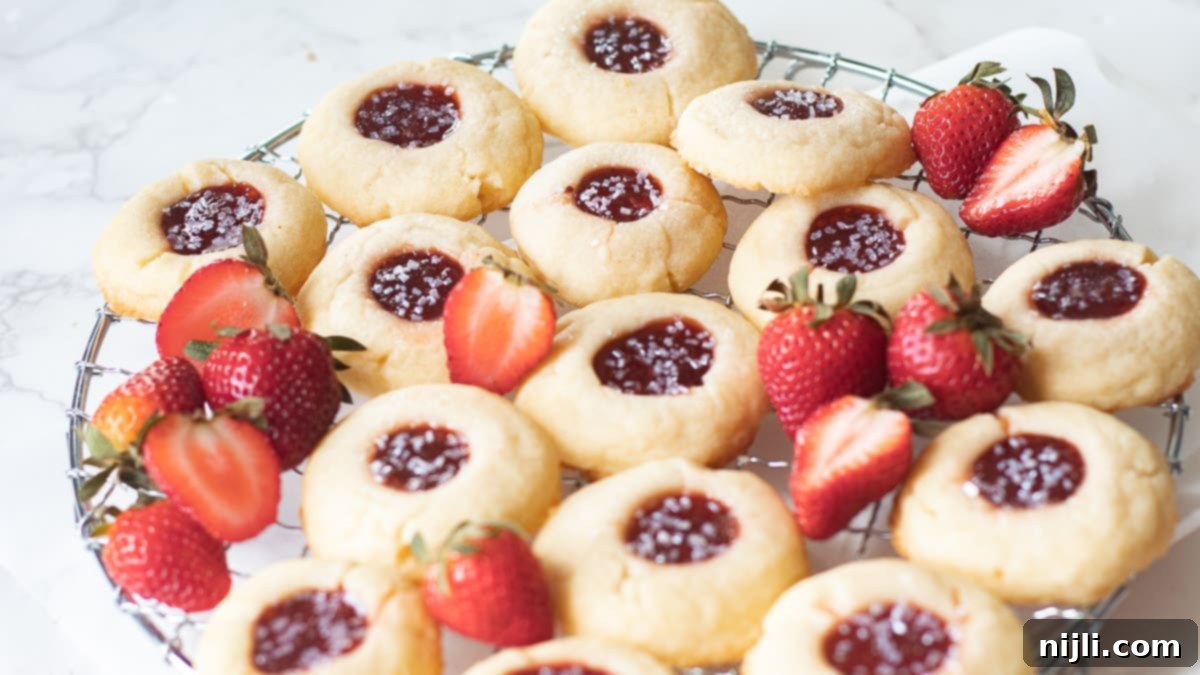 Strawberry Shortbread Delights 4 strawberry shortbread thumbprint cookies on a tray