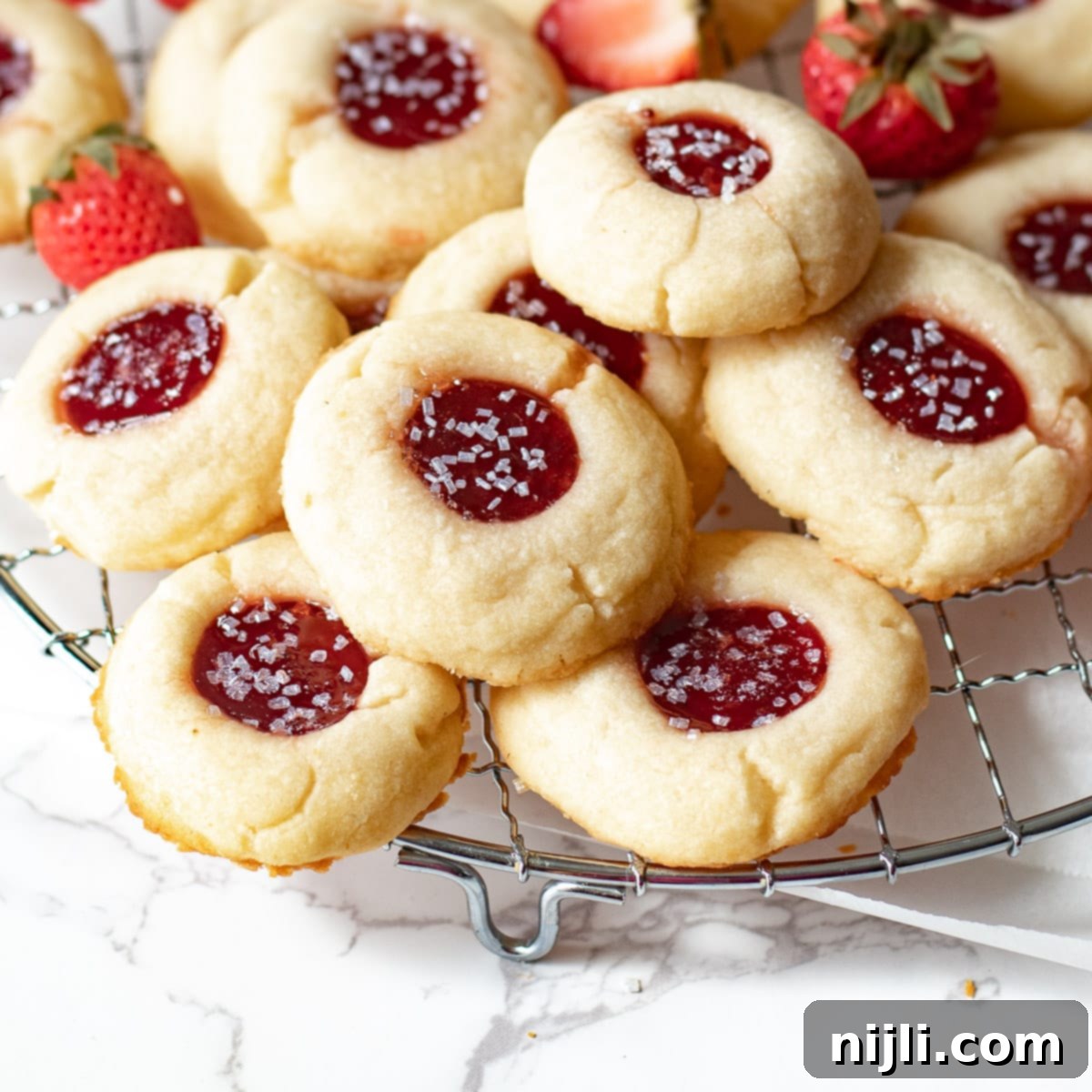 Strawberry Shortbread Delights 7 strawberry jam shortbread cookies on a wire rack