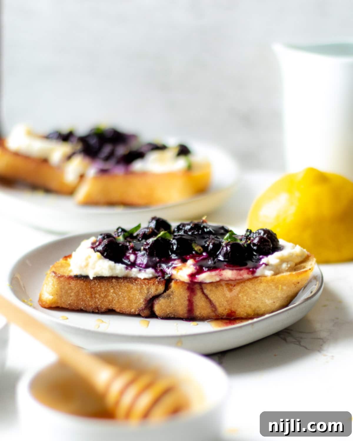 Creamy Whipped Ricotta and Blueberry Toast 5 ricotta blueberry toast with a spoon of blueberry compote