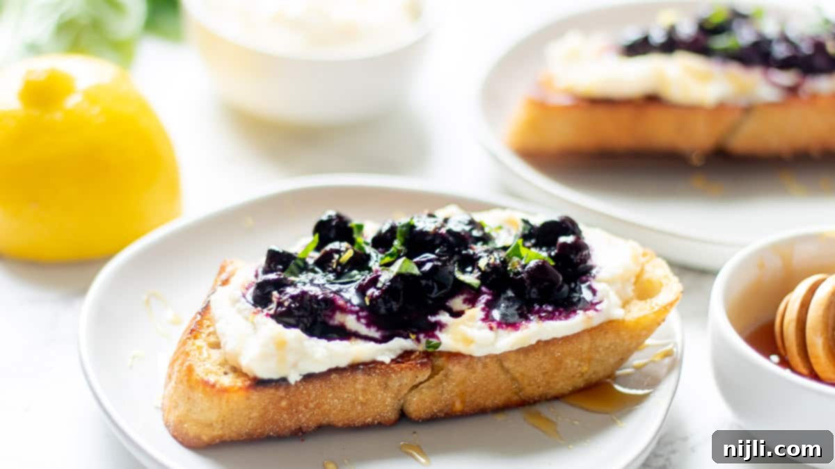 Creamy Whipped Ricotta and Blueberry Toast 6 ricotta blueberry toast on a white plate with a fork