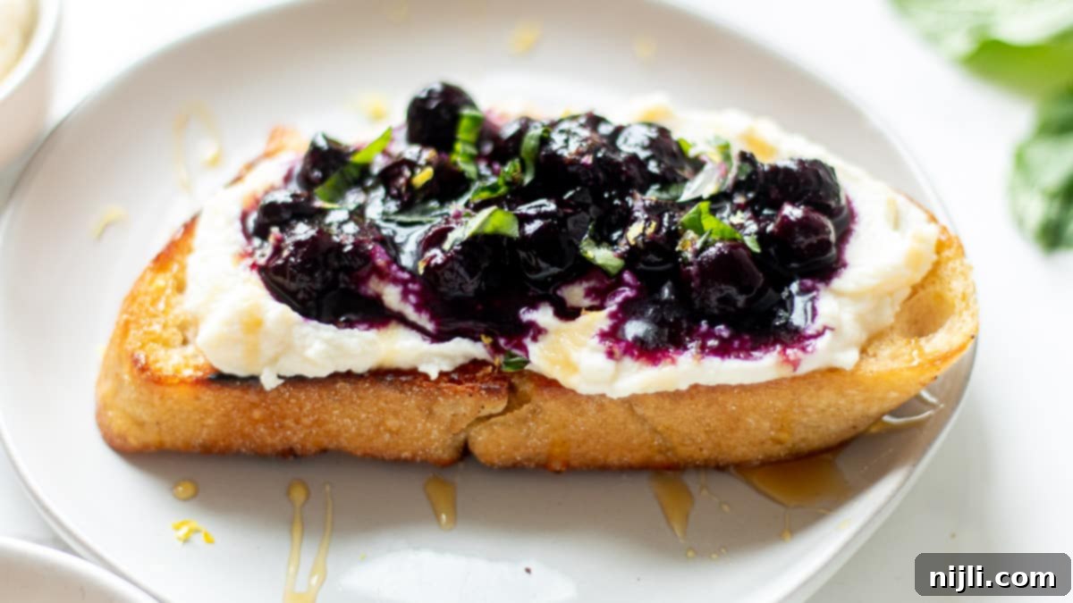 ricotta blueberry toast on a plate, garnished with mint