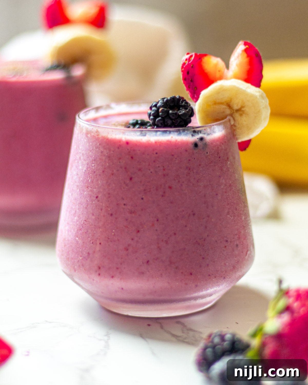 Triple Berry Banana Delight 3 blackberry strawberry banana smoothie in glasses with fruit garnish