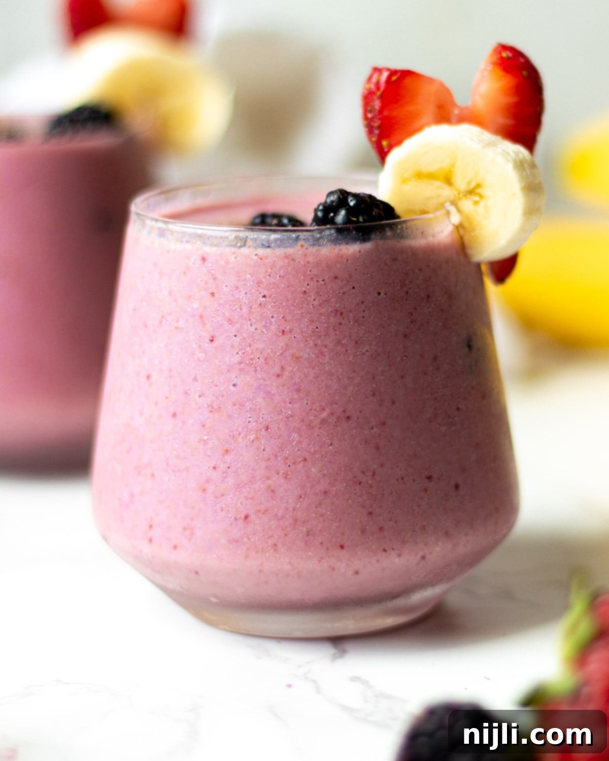 Triple Berry Banana Delight 5 blackberry strawberry banana smoothie in glasses with fruit garnish