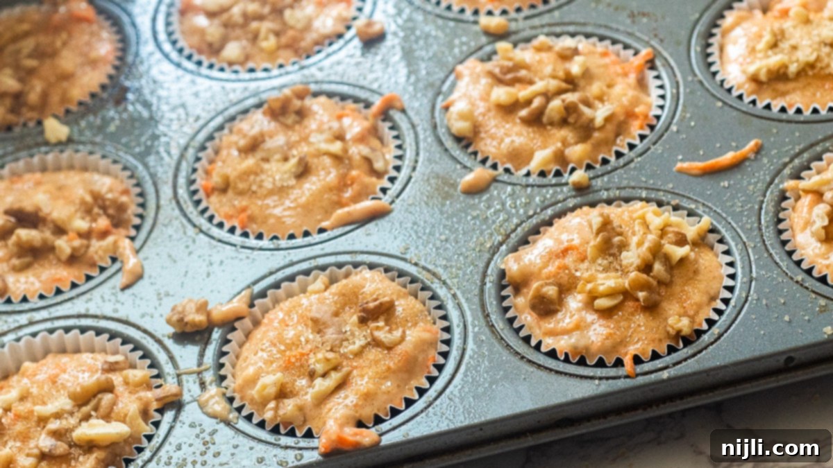 Golden Carrot Banana Muffins 6 Unbaked vegan banana carrot muffin batter in a tin, ready for the oven.