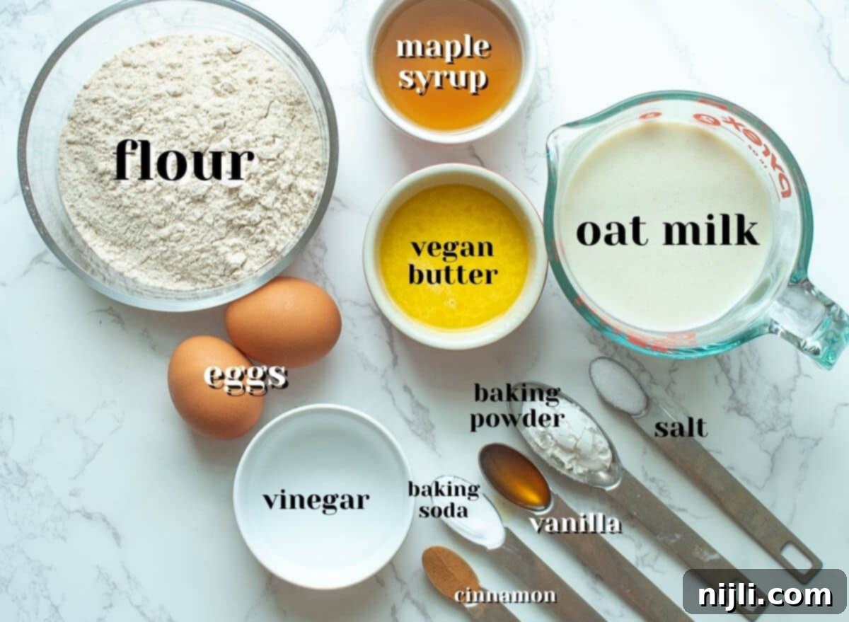 Fluffy Oat Milk Bliss 7 A selection of fresh ingredients laid out, including oat milk, flour, eggs, and maple syrup, ready for making American pancakes.