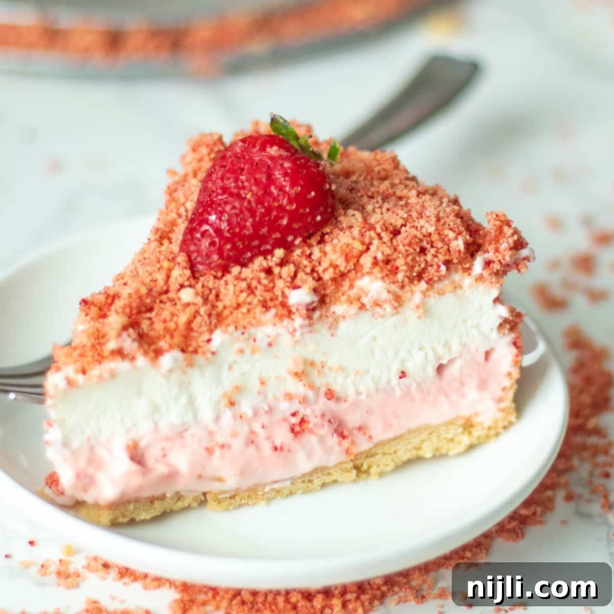 Strawberry Crunch Cheesecake 2 A perfectly sliced no-bake strawberry crunch cheesecake, showcasing its creamy layers and crunchy topping.