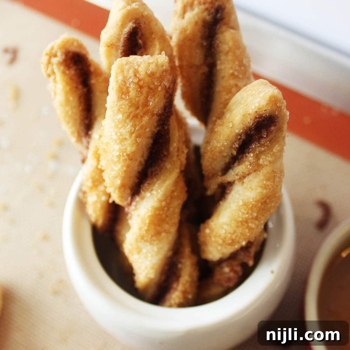 Flaky Pastry Twists 3 pie crust cookies twists arranged on a wooden surface