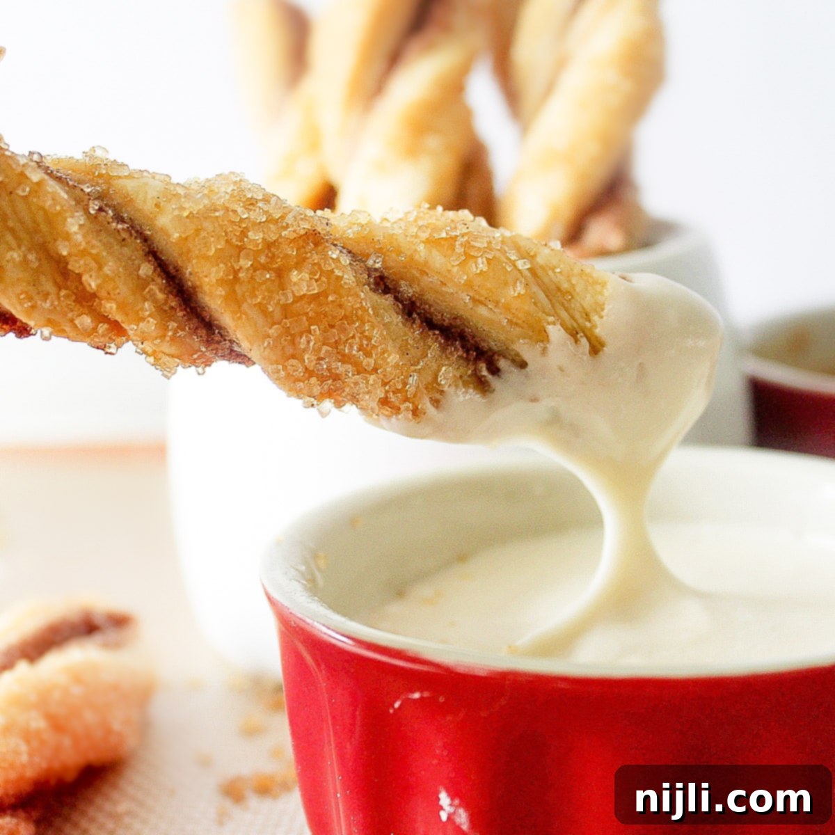 Flaky Pastry Twists 5 pie crust cookies twists being dipped into a sauce