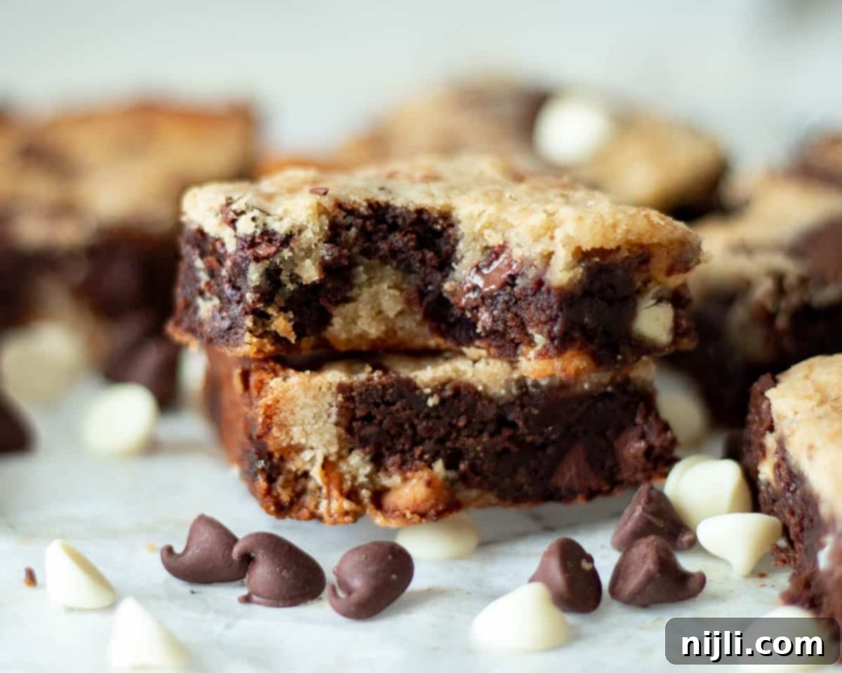 Close-up of stacked fudge blondie recipe bars, showing the gooey texture and distinct layers.