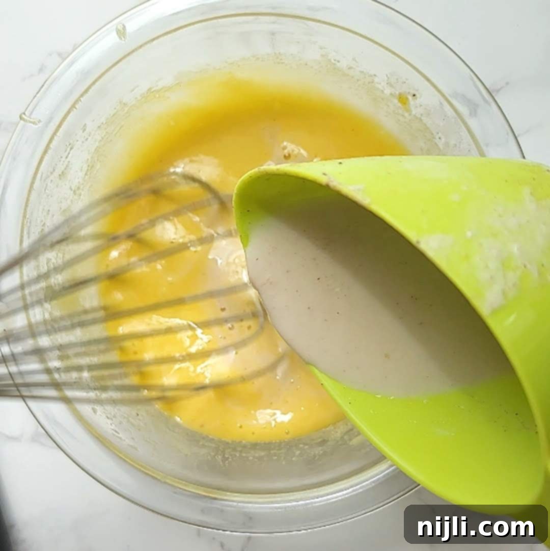 Spiced Oat Milk Cheer 11 Step 6: Straining the cooled eggnog and adding vanilla and rum extract.