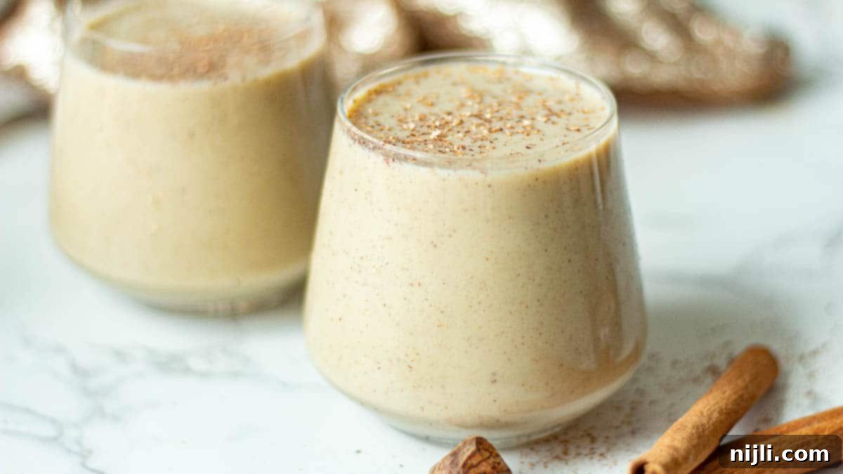 Spiced Oat Milk Cheer 13 A festive holiday setting with eggnog in glasses, ready to be enjoyed with holiday treats.