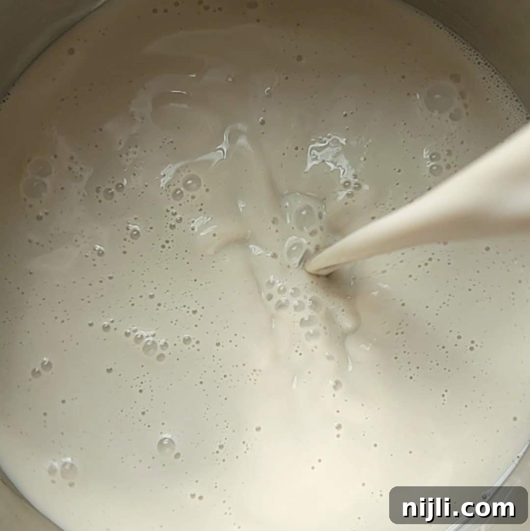 Spiced Oat Milk Cheer 7 Step 2: Heating oat milk in a saucepan over medium heat with spices.