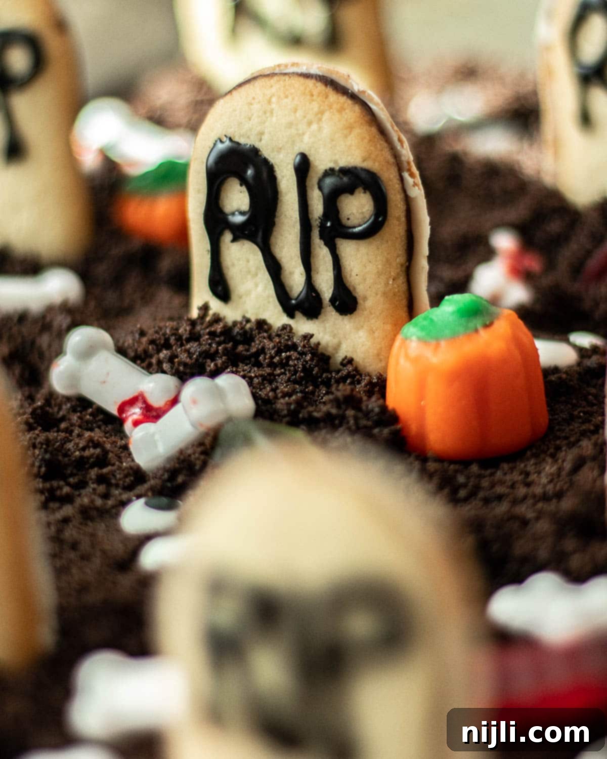Tombstone Brownies 5 A close-up of a decorated Halloween pudding dessert, showcasing intricate details and various Halloween candies.
