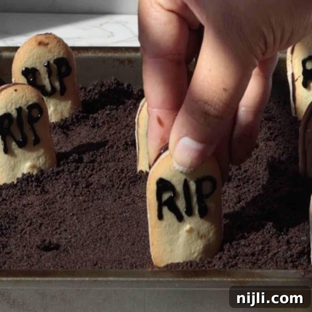 Tombstone Brownies 7 Step 2: Placing decorated Milano cookies upright into the brownie 'dirt' as tombstones.