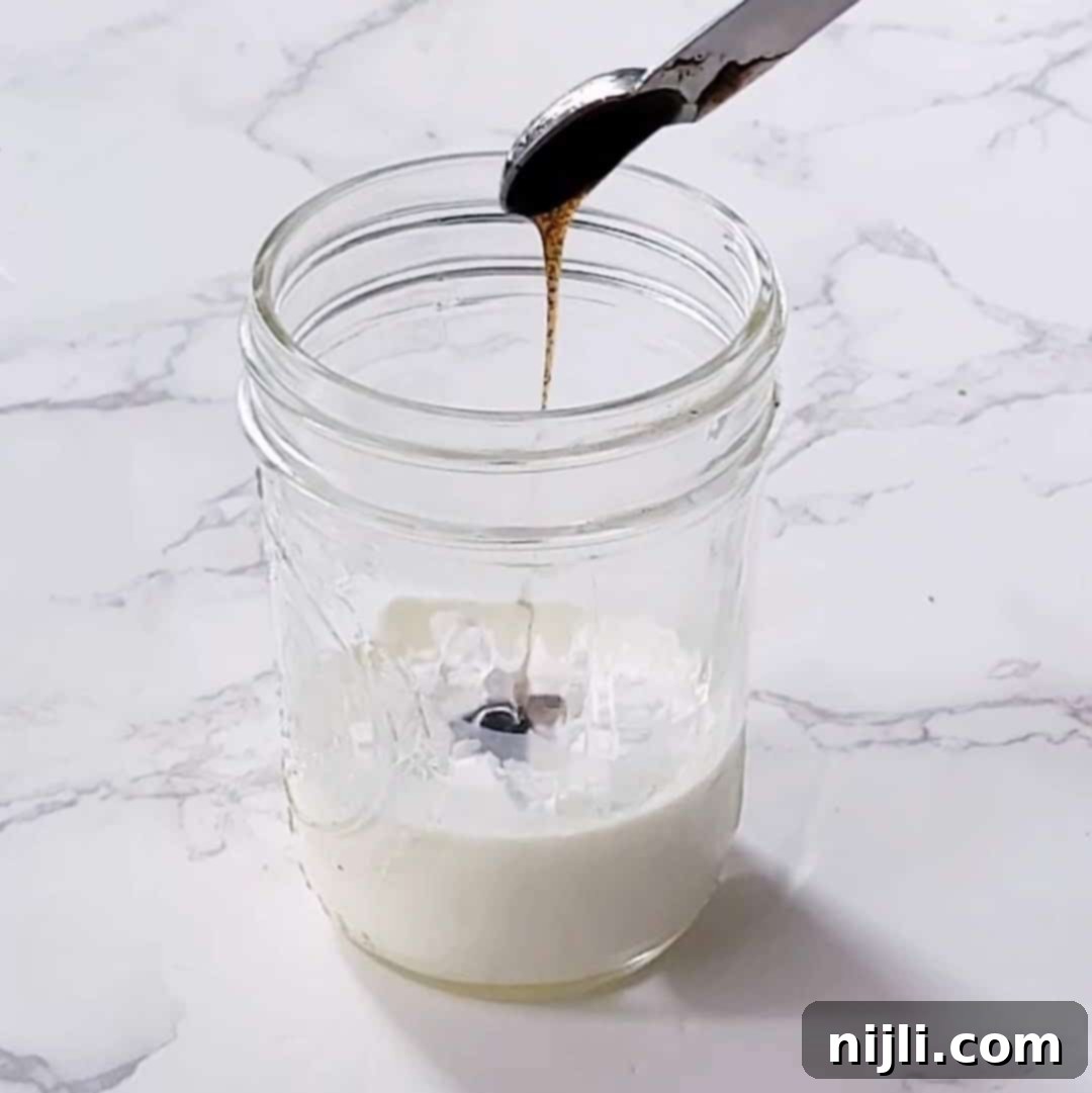 Homemade Sweet Cream Cold Foam 6 Step 1: Combining cold milk, powdered sugar, and vanilla bean paste in a cup