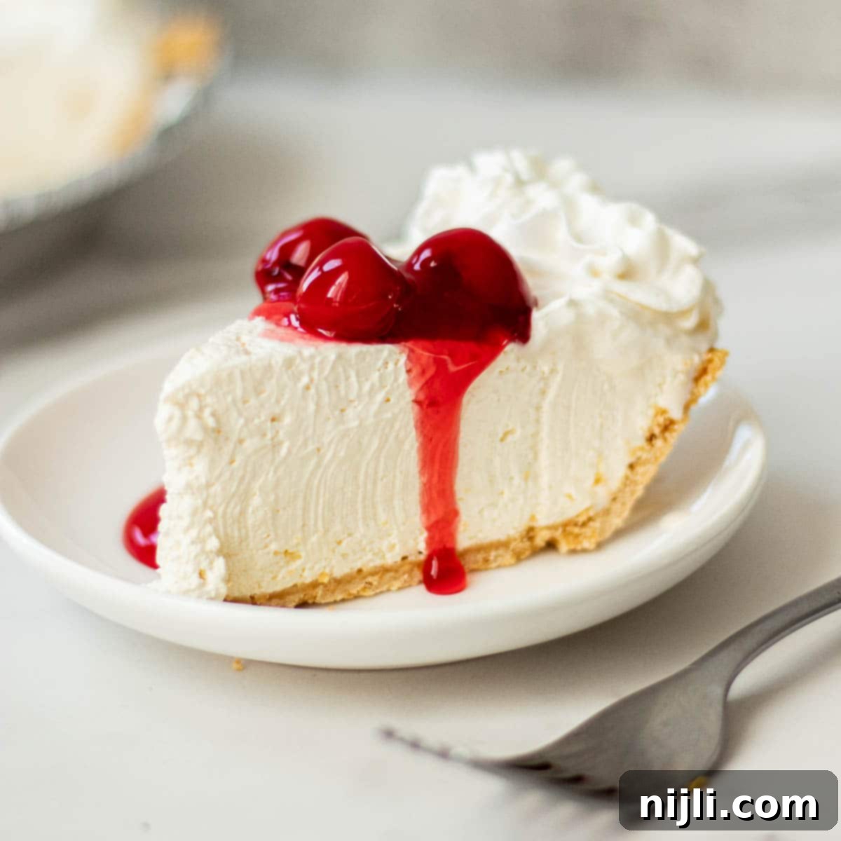 No-Bake Philadelphia Cool Whip Cheesecake 2 A perfectly sliced no-bake Philadelphia cheesecake with Cool Whip, ready to be enjoyed.