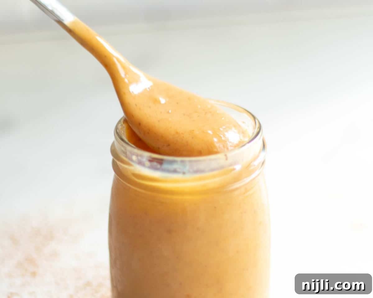 Starbucks Pumpkin Spice Sauce 3 Close-up of a jar of homemade Starbucks pumpkin sauce, showcasing its smooth, creamy texture and rich fall color. Perfect for how to make Starbucks pumpkin sauce for coffee.
