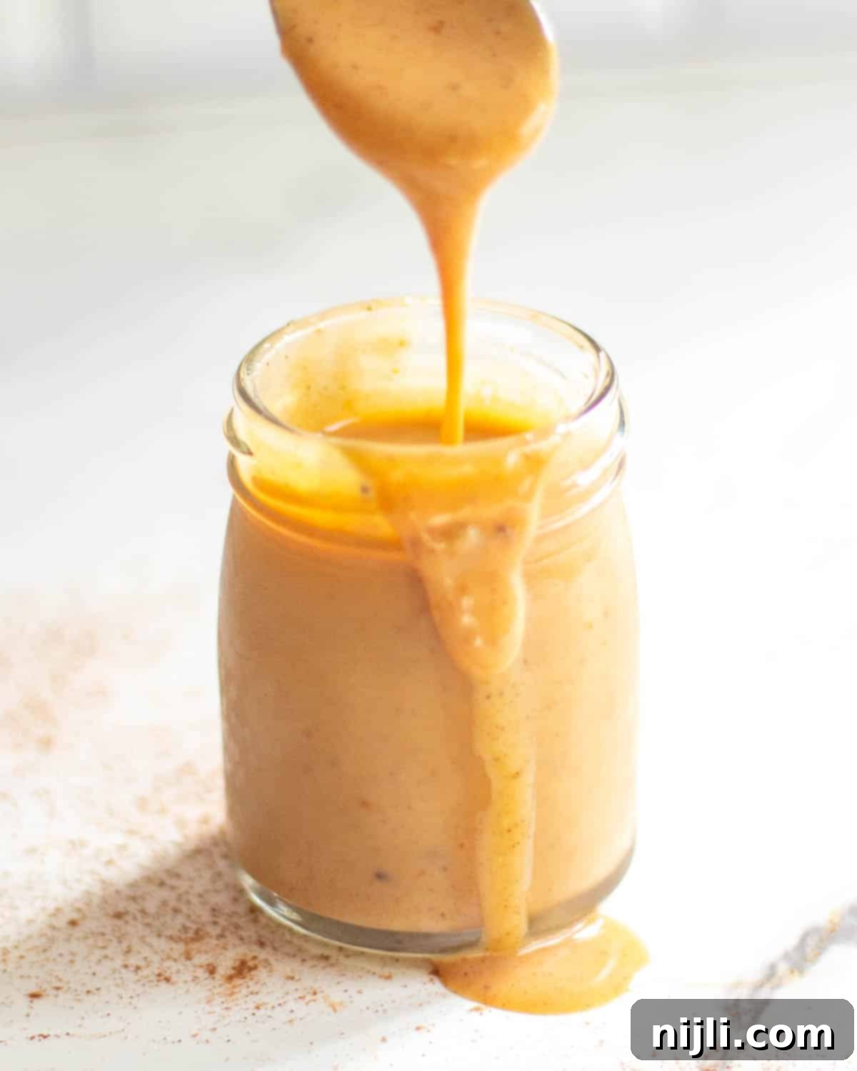 Starbucks Pumpkin Spice Sauce 4 A close-up shot of the homemade pumpkin spice sauce in a clear glass jar, highlighting its vibrant color and inviting texture.