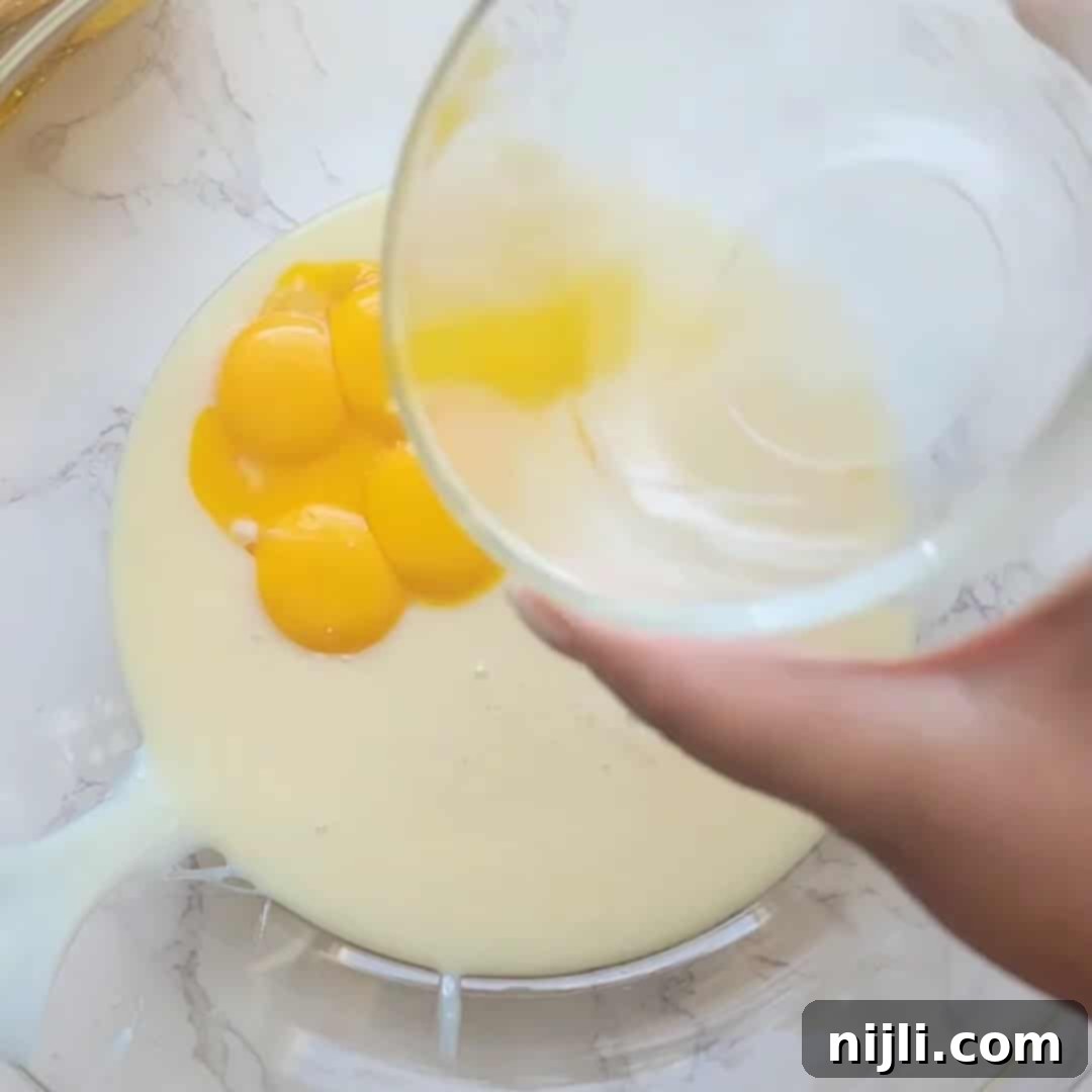 Zesty Lemon Icebox Pie 9 Pouring egg yolks into lemon icebox pie batter.