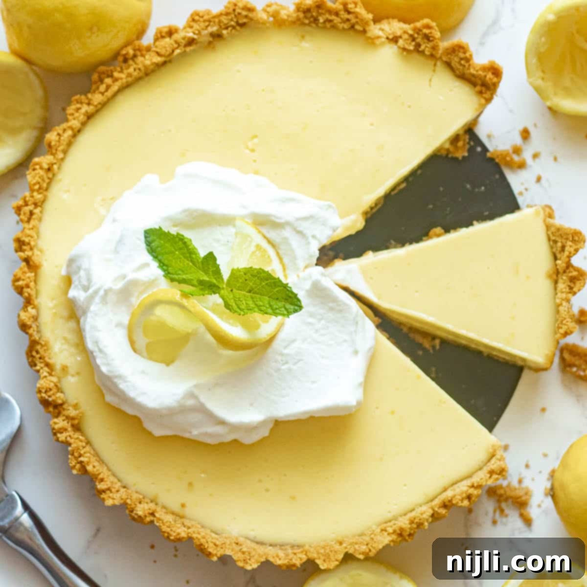 Zesty Lemon Icebox Pie 13 lemon icebox pie with slices cut out
