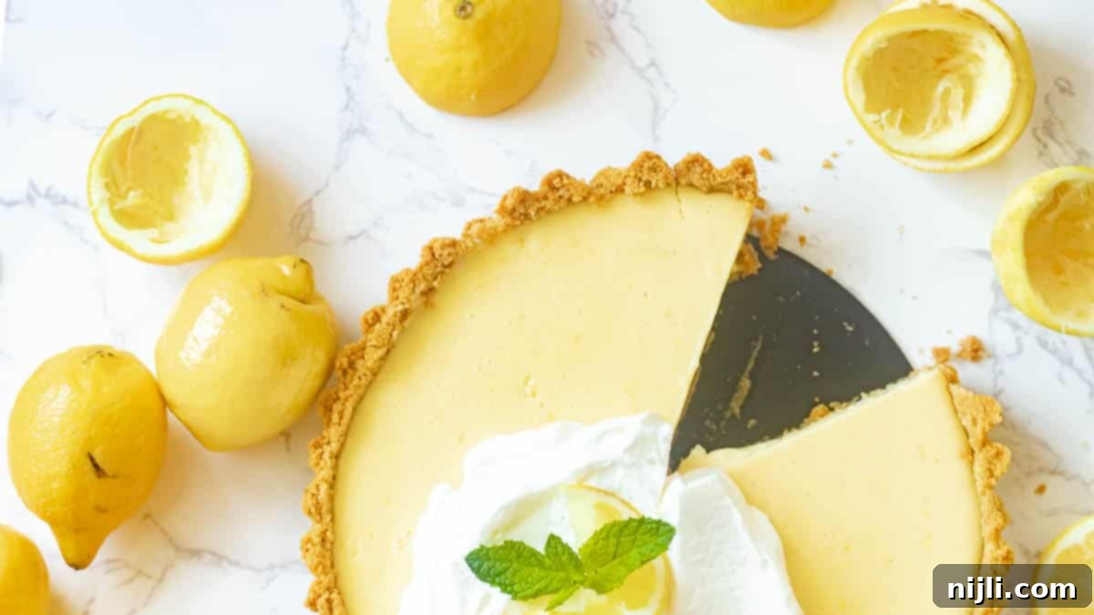 Zesty Lemon Icebox Pie 4 lemon icebox pie with slices cut out and lemons surrounding