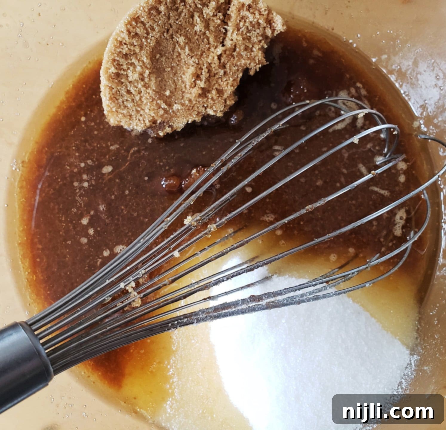 Effortless 4-Ingredient Banana Bread 6 Brown butter, brown sugar, and white sugar in a bowl with a whisk, preparing to mix to make triple chocolate brownies.