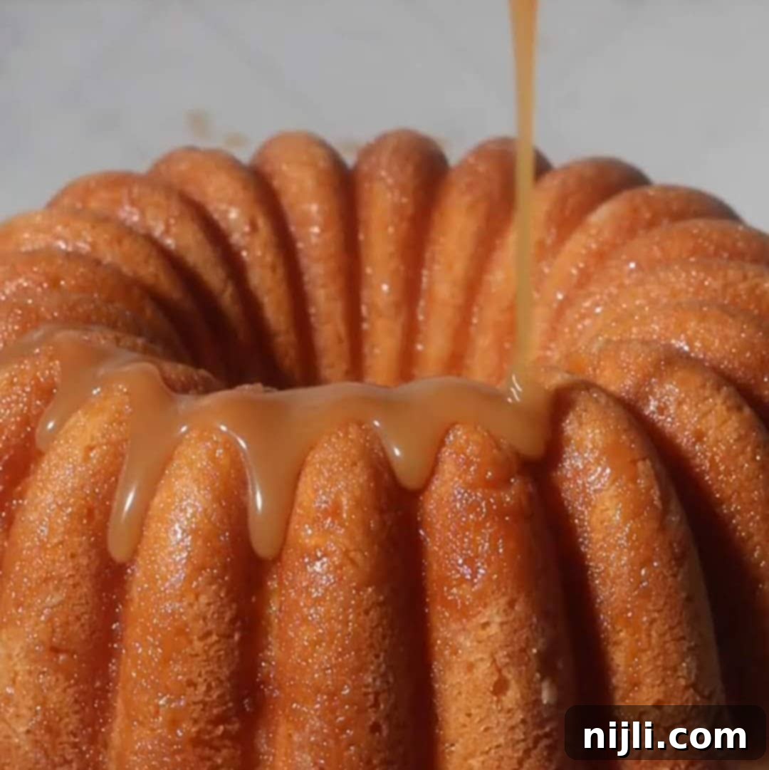 Golden Kentucky Butter Cake with Salted Caramel Glaze 14 drizzling caramel sauce on a salted caramel kentucky butter cake