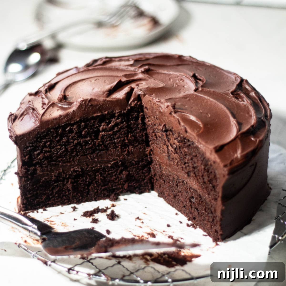 Matilda's Decadent Chocolate Cake 2 A whole, perfectly frosted Matilda's Chocolate Cake, rich and dark, standing proudly on a white marble surface, ready to be sliced and enjoyed.