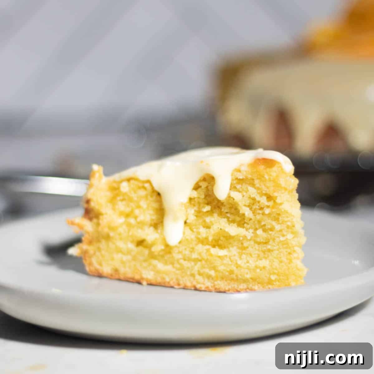 Mediterranean Gluten-Free Olive Oil Cake 2 A beautifully glazed gluten-free olive oil cake, featuring a golden-brown exterior and a luscious orange topping, ready to be served.
