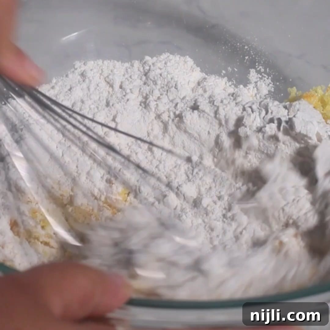 Mediterranean Gluten-Free Olive Oil Cake 8 Whisking 1-to-1 gluten-free flour blend, baking powder, and salt into the sugar and zest mixture to prepare the dry ingredients for the olive oil cake batter.