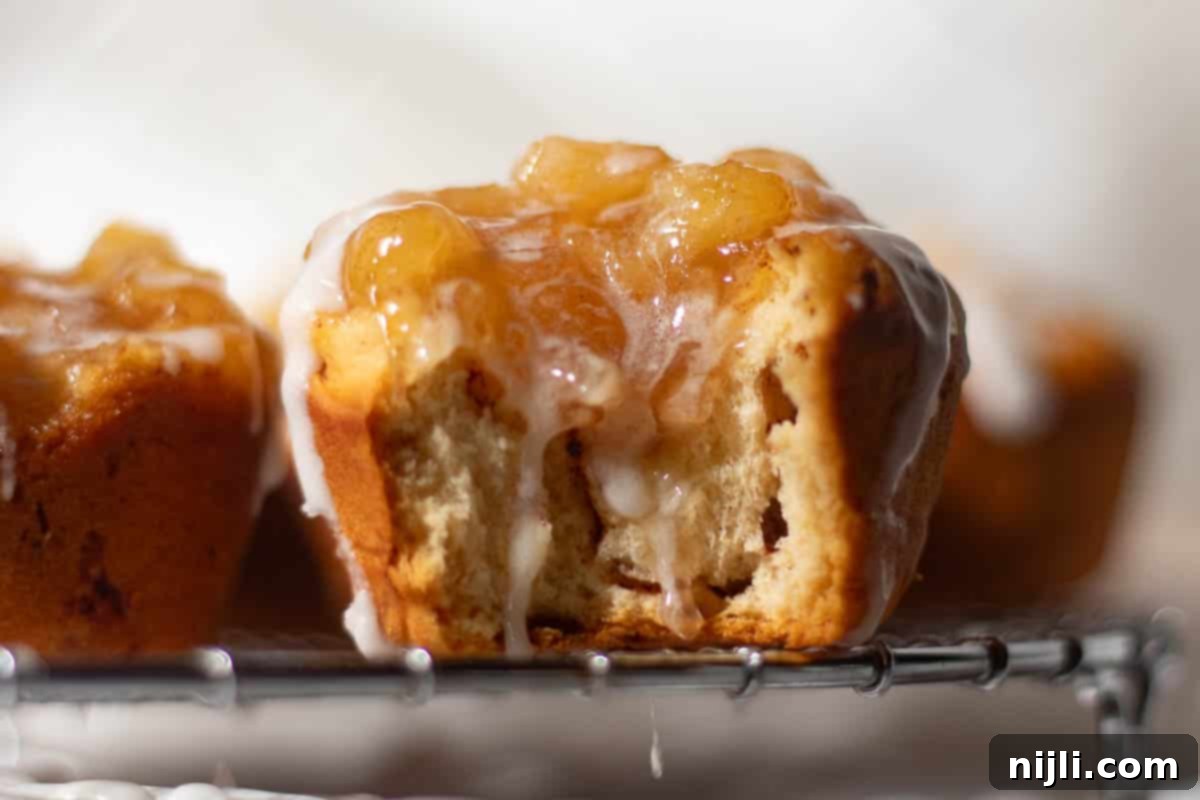 Cinnamon Swirl Apple Pies 3 Cinnamon roll apple pies made with refrigerated cinnamon rolls and canned apple pie filling, sitting on a wire cooling rack with icing drizzled over the top.
