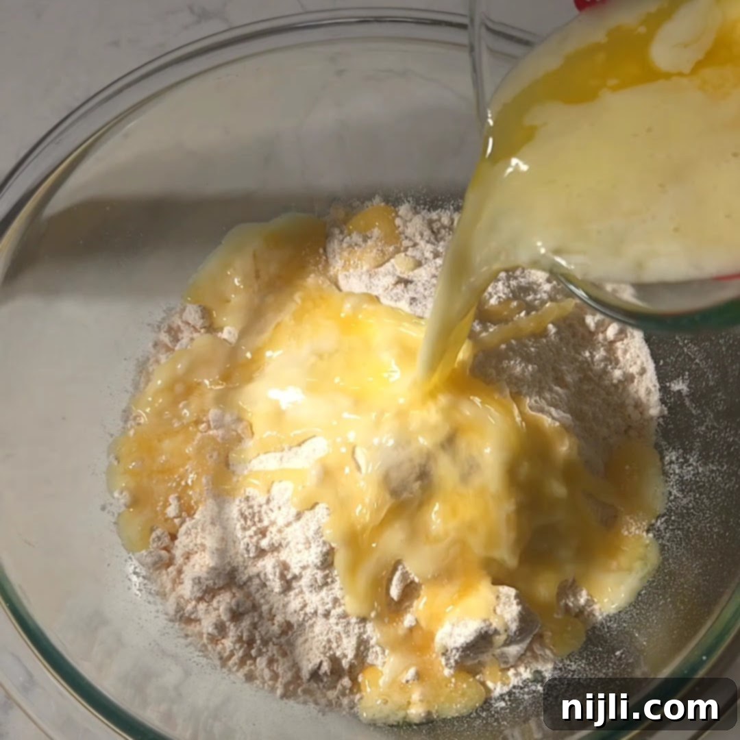 Effortless Cake Mix Apple Cobbler 8 Melted butter being poured over dry yellow cake mix in a bowl, one of the steps in making apple cobbler with yellow cake mix.