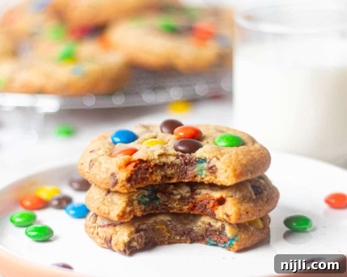 M&M Burst Chocolate Chip Goodness 3 A batch of M&M chocolate chip cookies freshly baked and arranged on a plate, combining semi-sweet chocolate chips with colorful M&Ms in a thick, chewy cookie base. This recipe delivers a balance of gooey chocolate chips and crunchy candy, ideal for anyone seeking the ultimate M&M chocolate chip cookie experience.