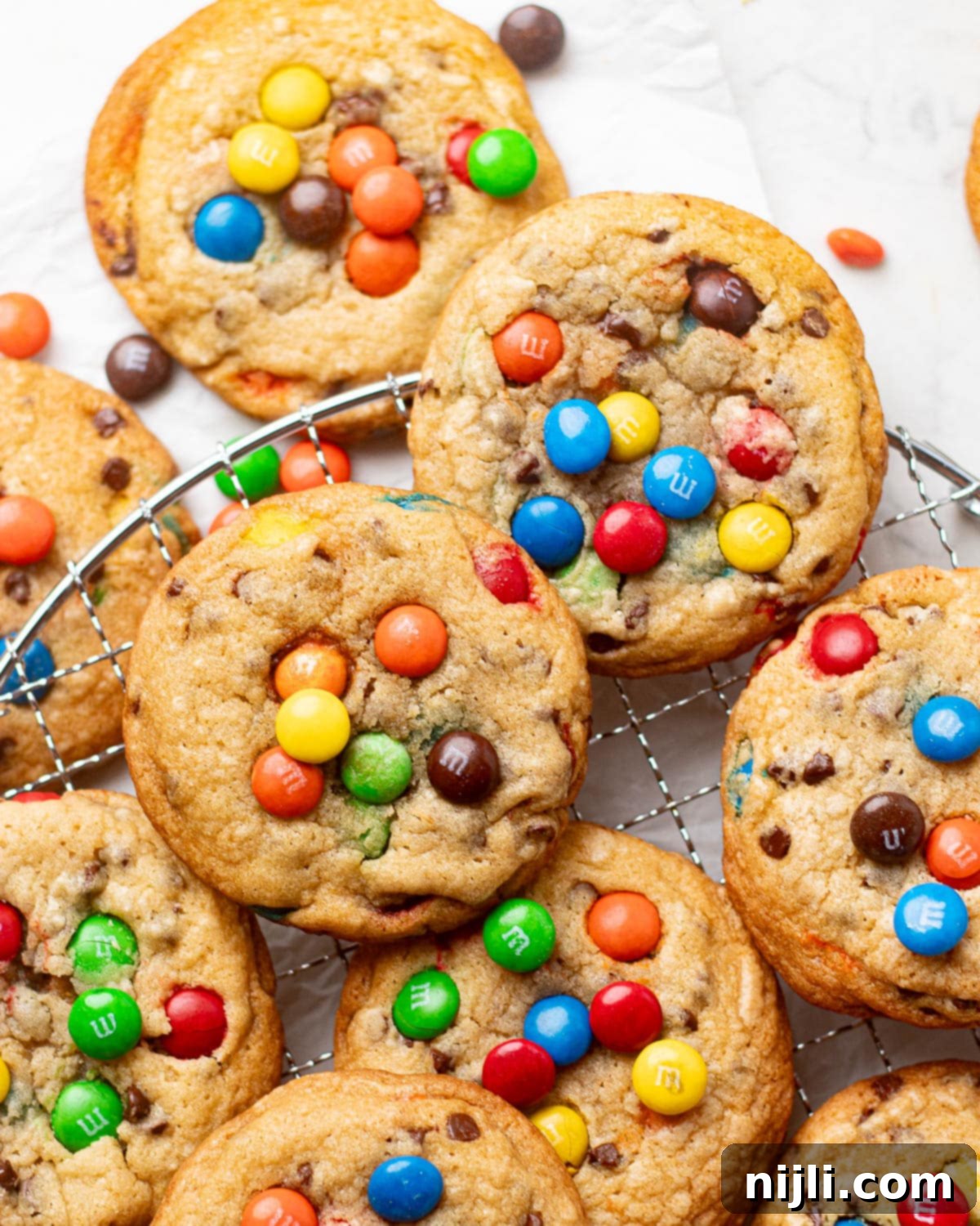 M&M Burst Chocolate Chip Goodness 7 Golden-brown M&M cookies loaded with bright, candy-coated chocolates, highlighting the classic M&M cookie recipe loved by all ages. These cookies have a slightly crisp edge and a soft center, making them a timeless, colorful snack or dessert option.
