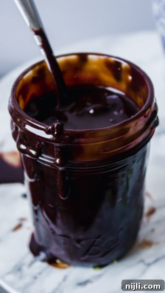 Decadent Amarena Cherry Chocolate Sauce 3 Glass bowl of Amarena Cherry Chocolate Sauce with a spoon