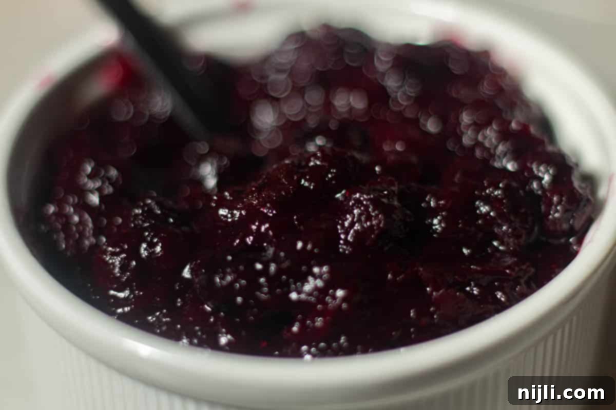 Heavenly Blueberry Cake Filling 3 Homemade blueberry cake filling in a ramekin, thick and vibrant with visible cooked berries.