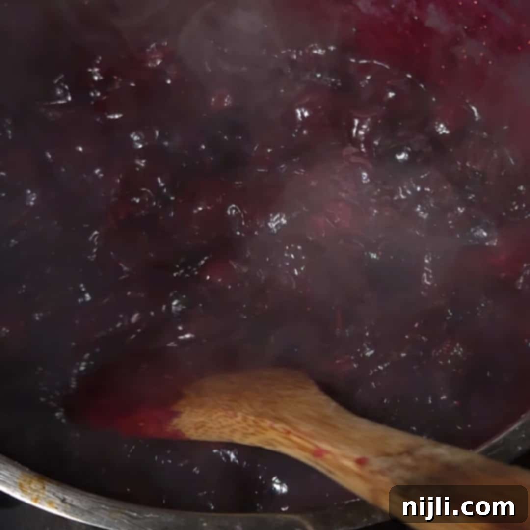 Heavenly Blueberry Cake Filling 7 Blueberries simmering on the stove, thickening into a rich and glossy blueberry cake filling.